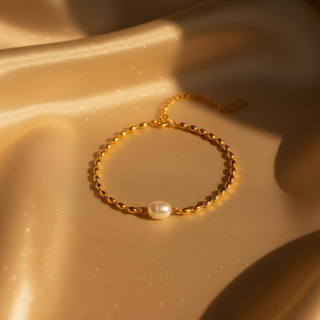 Gold oval bead chain bracelet with freshwater pearl on warm amber golden silk