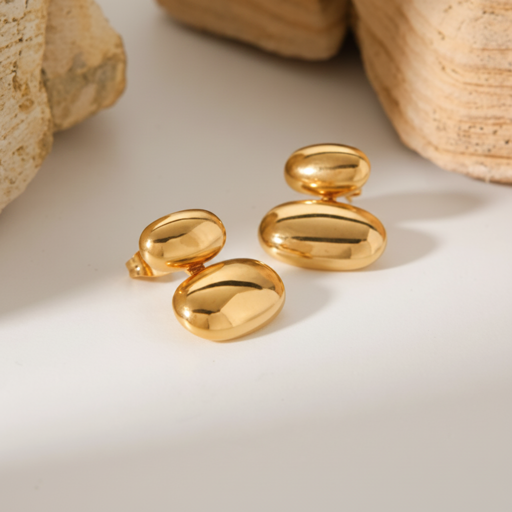 Close-up of smooth 18K gold-plated oval bean stud earrings